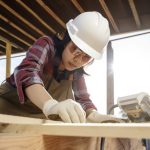 female skilled carpenter working in helmet